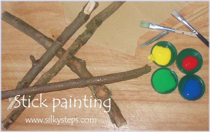 Stick and twig painting outdoor play activity idea for preschool nursery children